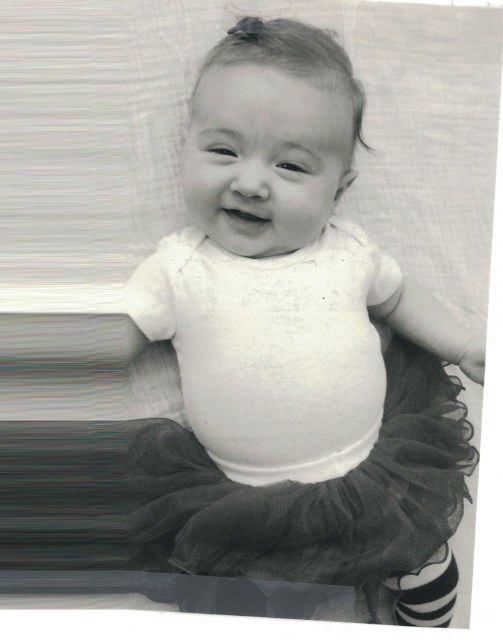 A smiling baby in Mama Raj’s care